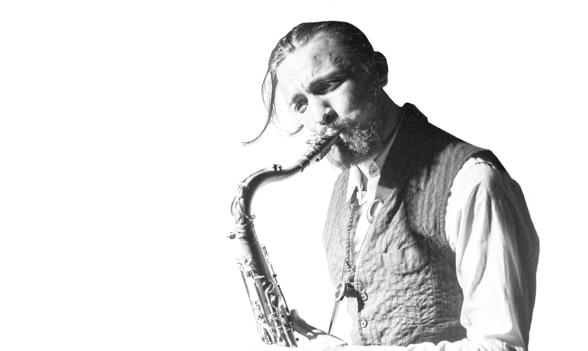 black and white photo of Aurélien Tomasi blowing in his tenor saxophone. Photo credited to Peter Graham. Design by musicos Productions